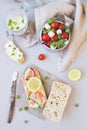 Fresh tomato salad and ciabatta bread with cream cheese and salmon on the gray background