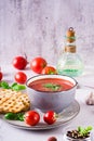 Fresh tomato soup with basil in a bowl and fresh vegetables on the table. Vertical view Royalty Free Stock Photo