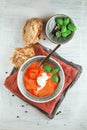 Fresh Tomato soup in a bowl with tomatoes and basil on a white kitchen table Royalty Free Stock Photo