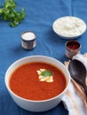 Fresh tomato soup. Seasonal summer dish. Located on a blue linen tablecloth. Nearby lies a spoon on a white cotton napkin. Bread Royalty Free Stock Photo