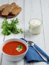 Fresh tomato soup. Seasonal summer dish. Located on a vintage white background. Nearby is a spoon on a blue cotton napkin. Bread Royalty Free Stock Photo