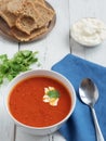 Fresh tomato soup. Seasonal summer dish. Located on a vintage white background. Nearby is a spoon on a blue cotton napkin. Bread Royalty Free Stock Photo