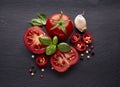 Fresh  tomatoes, basil, garlic on black  stone background Royalty Free Stock Photo