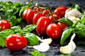 Fresh tomatoes with basil garlic and sea salt on black slate background Royalty Free Stock Photo