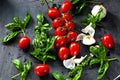 Fresh tomatoes with basil garlic and sea salt on black slate background Royalty Free Stock Photo