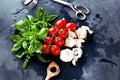 Fresh tomatoes with basil garlic and sea salt on black slate background Royalty Free Stock Photo