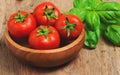 Fresh tomatoes in a basket with mint.Wooden table Royalty Free Stock Photo