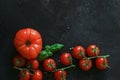 Fresh tomatoes on a black background with spices. Top view