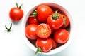 Fresh tomatoes in bowl on white table. Top view, copy space. Red cherry tomato stack on white background. fresh tomatoes with wate Royalty Free Stock Photo