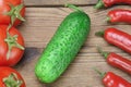 Fresh Tomatoes, Chili Peppers and Cucumber On Wooden Board