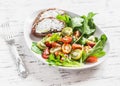 Fresh tomatoes and garden herbs salad and cheese sandwich on a white ceramic plate on a light wooden background. Royalty Free Stock Photo