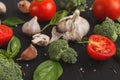 Fresh tomatoes and garlic closeup on dark rustic wood Royalty Free Stock Photo