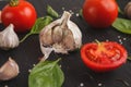 Fresh tomatoes and garlic closeup on dark rustic wood Royalty Free Stock Photo