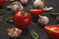 Fresh tomatoes and garlic closeup on dark rustic wood Royalty Free Stock Photo