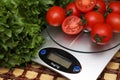 Fresh tomatoes on kitchen scales weighing Royalty Free Stock Photo