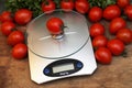 Fresh tomatoes on kitchen scales weighing Royalty Free Stock Photo