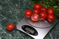 Fresh tomatoes on kitchen scales weighing Royalty Free Stock Photo