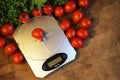 Fresh tomatoes on kitchen scales weighing Royalty Free Stock Photo