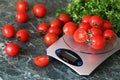 Fresh tomatoes on kitchen scales weighing Royalty Free Stock Photo