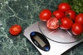 Fresh tomatoes on kitchen scales weighing Royalty Free Stock Photo