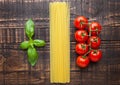 Fresh tomatoes with raw spagetti and basil on gunge background Royalty Free Stock Photo