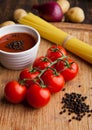 Fresh tomatoes with raw spagetti and pepper on kitchen board Royalty Free Stock Photo