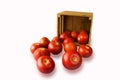 Fresh tomatoes on the vine and a cut one in a wooden crate on a Royalty Free Stock Photo