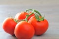 Fresh tomatoes with water droplets closeup, on the wooden kitchen table Royalty Free Stock Photo