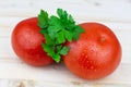 Fresh tomatoes with waterdrops and parsley on a wooden table