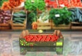 Fresh tomatos in box on market background with reflection 3d