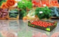 Fresh tomatos in box on market background with reflection and place for text 3d