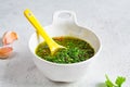 Fresh traditional chimichurri sauce for barbecue meat in glass jar, light background, top view