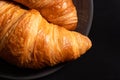 Fresh traditional croissants on a black background. Top view, Copy space