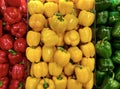 Fresh tricolor red yellow green bell peppers store on a counter in the supermarket. Royalty Free Stock Photo