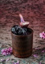 Fresh tropical alcoholic cocktail with vodka, ice, passion fruit in wooden glass with flame on textured background. Summer cold