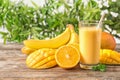 Fresh tropical drink with ripe mango, orange and banana on wooden table Royalty Free Stock Photo