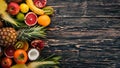 Fresh Tropical Fruits. Pineapple, coconut, kiwi, orange, pomegranate, grapefruit. On a wooden background. Top view. Royalty Free Stock Photo