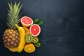 Fresh Tropical Fruits. Pineapple, coconut, kiwi, orange, pomegranate, grapefruit. On a wooden background. Top view. Royalty Free Stock Photo