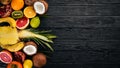 Fresh Tropical Fruits. Pineapple, coconut, kiwi, orange, pomegranate, grapefruit. On a wooden background. Top view. Royalty Free Stock Photo