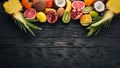 Fresh Tropical Fruits. Pineapple, coconut, kiwi, orange, pomegranate, grapefruit. On a wooden background. Top view. Royalty Free Stock Photo