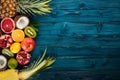 Fresh Tropical Fruits. Pineapple, coconut, kiwi, orange, pomegranate, grapefruit. On a wooden background. Top view. Royalty Free Stock Photo