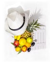 Fresh, ripe tropical fruits in a wooden box and summer hat on a white background Royalty Free Stock Photo