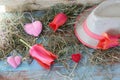 Fresh tulips, hearts decor, straw hat, hay on a wooden surface Royalty Free Stock Photo