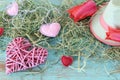 Fresh tulips, hearts decor, straw hat, hay on a wooden surface Royalty Free Stock Photo