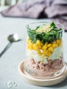 Fresh tuna salad with egg corn greens in a glass Cup on a concrete table. copy space Royalty Free Stock Photo