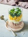 Fresh tuna salad with egg corn greens in a glass Cup on a concrete table. copy space Royalty Free Stock Photo