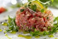 Fresh Tuna Tartare with Lemon, Herbs and Olive Oil Dressing on Elegant White Plate, Healthy Gourmet Appetizer