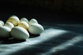 Fresh turkey eggs illuminated by a ray of light on a dark stone surface Royalty Free Stock Photo
