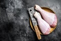 Fresh turkey legs Drumsticks, raw Poultry meat with butcher cleaver. Black background. Top view. Copy space Royalty Free Stock Photo