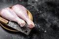 Fresh turkey legs Drumsticks, raw Poultry meat with butcher cleaver. Black background. Top view. Copy space Royalty Free Stock Photo